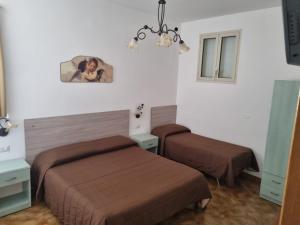 ein Schlafzimmer mit 2 Betten und einem Bild an der Wand in der Unterkunft Controvento in Porto Cesareo