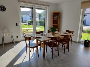 een eetkamer met een houten tafel en stoelen bij Gîte Sous les vents in Léglise