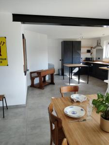 una sala da pranzo e una cucina con tavolo e sedie di Gîte Sous les vents a Léglise