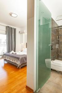 a bedroom with a bed and a glass shower at Unique Sea & Sunset Residence in Ixia