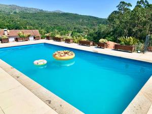 una piscina con dos inflables en el agua en Casa Valfonte - Moradia com piscina 