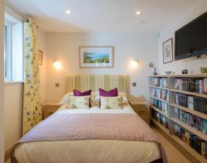 Un dormitorio con una cama grande con almohadas moradas. en Egloskerry, en Wadebridge