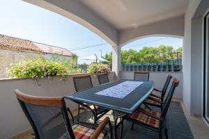 a patio with a table and chairs on a balcony at Modern apartment with private pool in Bibinje