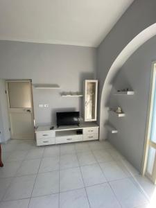 Il comprend un salon doté d'une télévision et de carrelage blanc. dans l'établissement Vollga Promenade Lovely 2 bedroom Apartment, à Durrës