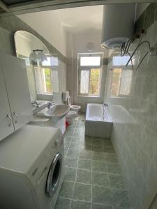 La salle de bains est pourvue d'un lave-linge. dans l'établissement Vollga Promenade Lovely 2 bedroom Apartment, à Durrës