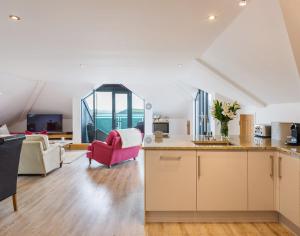 a kitchen and living room with a red chair at Upper Deck in Padstow