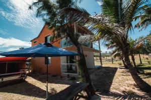 un paraguas azul sentado frente a una casa en Gravier beach house en Rodrigues Island