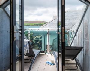 a balcony with chairs and a view of the water at Upper Deck in Padstow