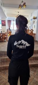 a woman is standing in a living room at Pensiune Restaurant TERRA in Ranca