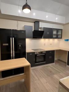 a kitchen with black appliances and a black refrigerator at Welsh Homestay in Pembroke Dock +23 photos