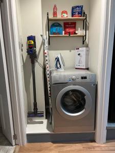 a laundry room with a washing machine and a shelf at Luxury Refurbished 2 Bedroom Regency Apartment in Cheltenham