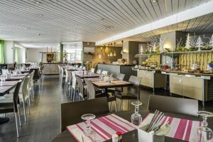 un restaurante con mesas y sillas y un bar en Hôtel Les 2 Alpes L'Orée Des Pistes, en Les Deux Alpes