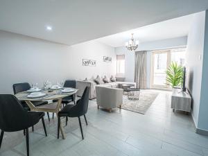 a living room with a table and chairs and a couch at Beautifully Decorated & Homely 2 Bed apartment in Dubai