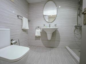 a bathroom with a sink and a toilet and a mirror at Beautifully Decorated & Homely 2 Bed apartment in Dubai
