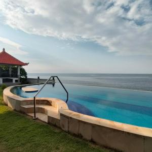a swimming pool with a view of the ocean at Coco Blu Villa in Singaraja