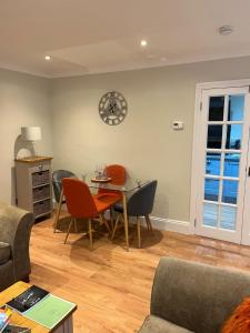 een woonkamer met een tafel en stoelen en een klok bij Luxury Refurbished 2 Bedroom Regency Apartment in Cheltenham