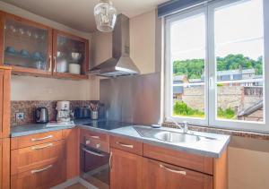 kuchnia ze zlewem i oknem w obiekcie Un air de vacances w mieście Honfleur