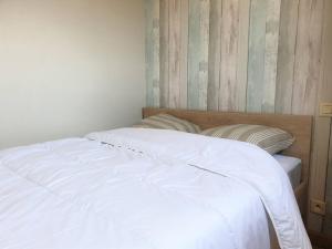 łóżko z białymi prześcieradłami i poduszkami w sypialni w obiekcie Appartement rénové centre Perros-Guirec avec balcon proche plage - FR-1-368-347 w mieście Perros-Guirec