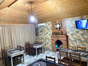 a dining room with two tables and a fireplace at Hotel Doko in Martvili