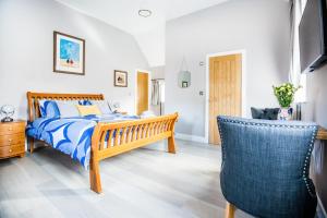 a bedroom with a bed and a chair at Little Regent Hall in Sheringham