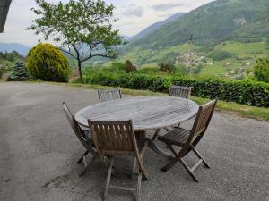 a wooden table and chairs with a view of mountains at la maison du haut de Freydon Ambiance Scandinave in Allevard