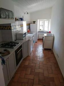 uma cozinha com electrodomésticos brancos e piso em azulejo em Casa sulla spiaggia di Boccadasse em Génova
