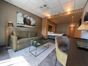 een woonkamer met een bank en een bed bij ´t Wapen van Marion in Oostvoorne