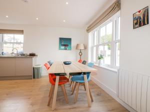 a kitchen and dining room with a wooden table and chairs at Gwel Nans in St. Agnes