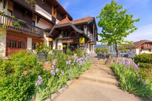 un edificio con fiori viola di fronte di Logis hôtel Annecy nord / Argonay ad Argonay