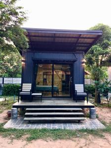 een blauwe schuilplaats met twee stoelen en een tafel bij The Loft Resort Kabin Buri in Kabin Buri