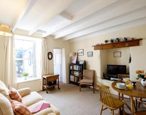 a living room with a couch and a table at Coppingers Cottage in Polzeath