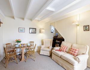 a living room with a couch and a table at Coppingers Cottage in Polzeath