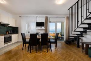 a kitchen and dining room with a table and chairs at Apartment Daisy in Vantačići