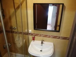 uma casa de banho com um lavatório, um chuveiro e um espelho. em Duque de conventus em Lisboa