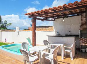 a patio with a table and chairs and a swimming pool at Espaço de Lazer - Casa com Piscina e Churrasqueira in Barra Grande