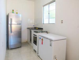 a kitchen with a stainless steel refrigerator and a dishwasher at Casa com Piscina e Churrasqueira em Vera Cruz BA in Barra Grande