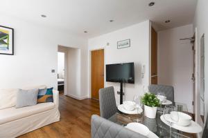 ein Wohnzimmer mit einem Sofa und einem Tisch in der Unterkunft Skyvillion - Lovely 2-Bed Central London Apartment in London