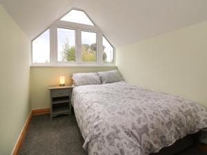 a small bedroom with a bed and a window at Hill Coach House in Watchet