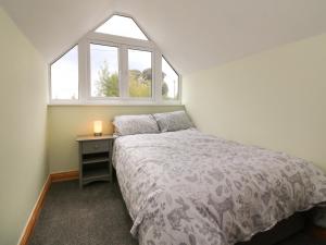 Un dormitorio pequeño con una cama y una ventana. en Hill Coach House, en Watchet
