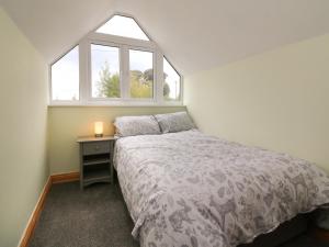 Habitación pequeña con cama y ventana en Hill Coach House, en Watchet