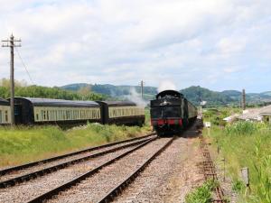 un tren que viaja por las vías junto a otro tren en Hill Coach House, en Watchet 7 fotos más