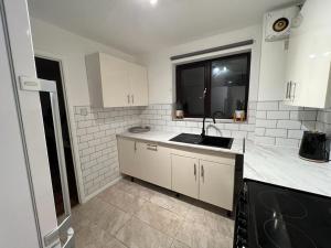 a white kitchen with a sink and a window at Impeccable 2-Bed Apartment in Grays London in Grays Thurrock