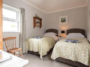 a bedroom with two beds and a sink and a window at Little Strand in Padstow