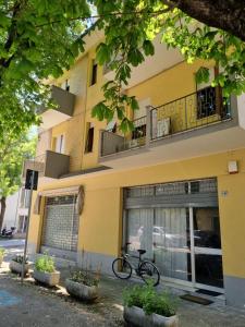 ein Fahrrad, das vor einem gelben Gebäude geparkt ist in der Unterkunft FAMILY HOME in Pesaro