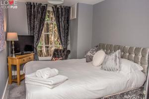 1 dormitorio con 1 cama con toallas en The Robin Hood Inn en Rowlands Castle