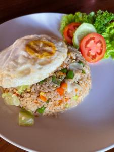 a plate of food with rice and vegetables on it at Lemon Guest House in Canggu