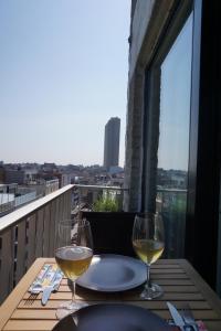 una mesa con 2 copas de vino blanco en el balcón en TheHeaven@7, en Ostende