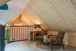 a attic room with a desk and two chairs at Wioska Radoska - Czerwona Stodoła na mazurach przez cały rok in Lichtenstein Ostpreussen