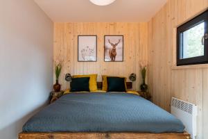 1 dormitorio con 1 cama y 2 cuadros en la pared en Wioska Radoska - Czerwona Stodoła na mazurach przez cały rok, en Lichtenstein Ostpreussen