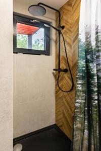 een douche in een badkamer met een raam bij Wioska Radoska - Czerwona Stodoła na mazurach przez cały rok in Lichtenstein Ostpreussen